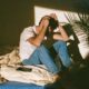 A man feeling like a failure while he sits on his bed