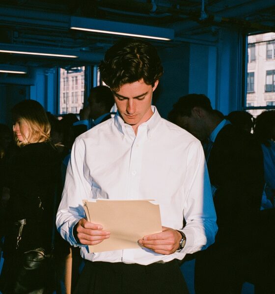 A CEO standing in his office holding a manila folder as he is facing legal challenges