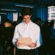 A CEO standing in his office holding a manila folder as he is facing legal challenges