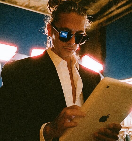 A male marketing director in a dimly lit studio holding a tablet looking at his fully automated content generation matrix