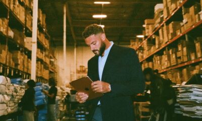 A man in his suit leading in a warehouse getting it organized