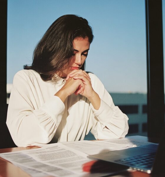 A woman sitting at her desk looking at debt relief options