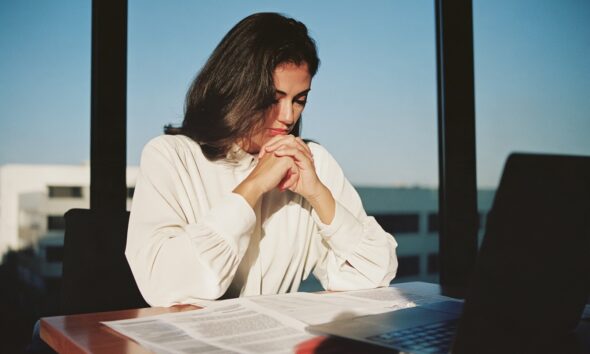 A woman sitting at her desk looking at debt relief options