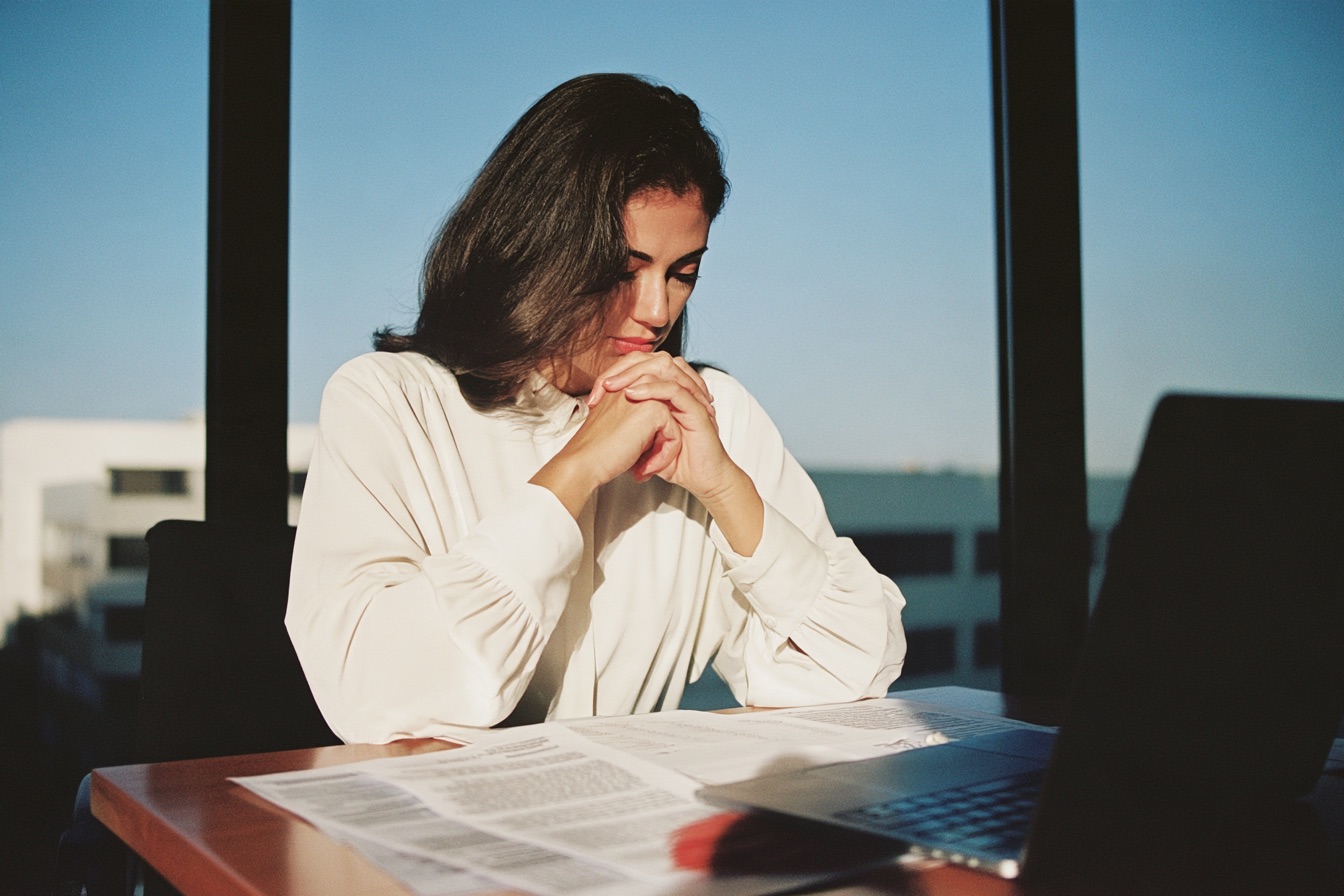 A woman sitting at her desk looking at debt relief options