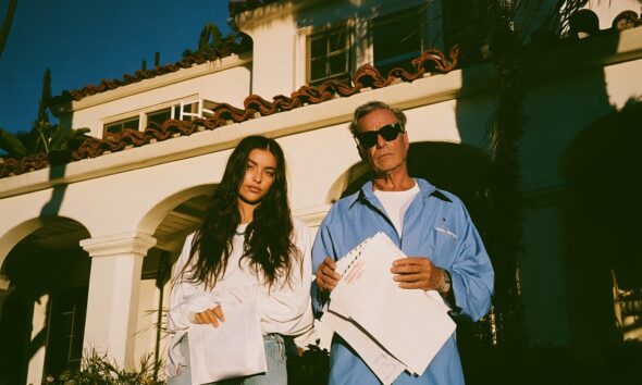 Father and adult daughter and she holding a buyout check envelope he is holding a refused deed papers