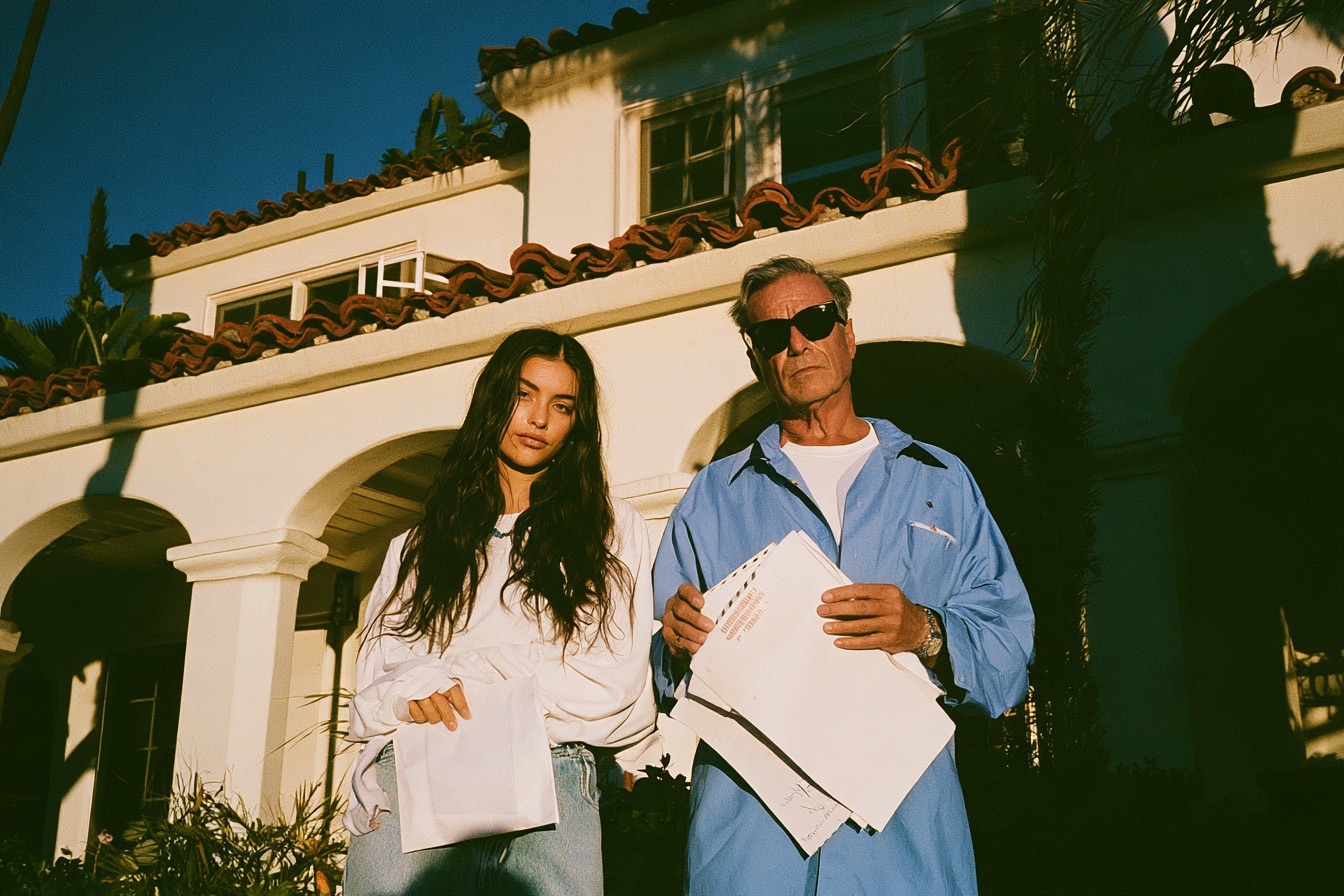 Father and adult daughter and she holding a buyout check envelope he is holding a refused deed papers