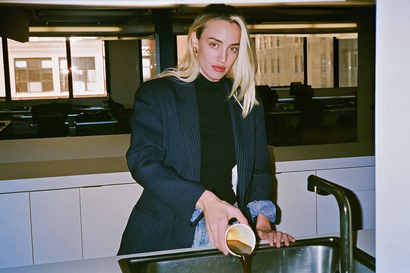 Female worker in burnout pouring her coffee down the sink