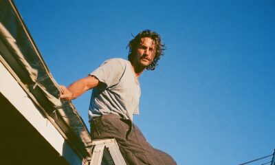Man on a ladder fixing the gutter of his luxury house roof