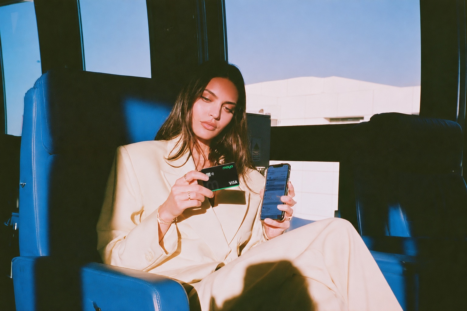 Woman holding black Maya bank card
