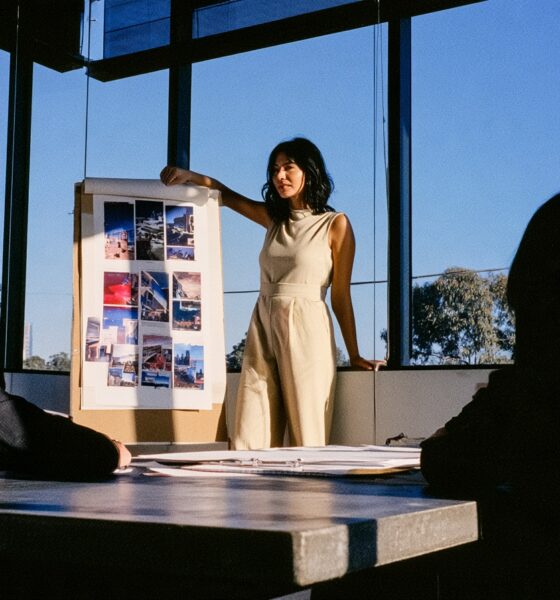 Woman standing at the front of a room pitching her marketing strategy to her creative team