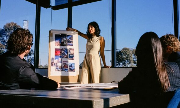 Woman standing at the front of a room pitching her marketing strategy to her creative team