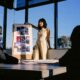 Woman standing at the front of a room pitching her marketing strategy to her creative team