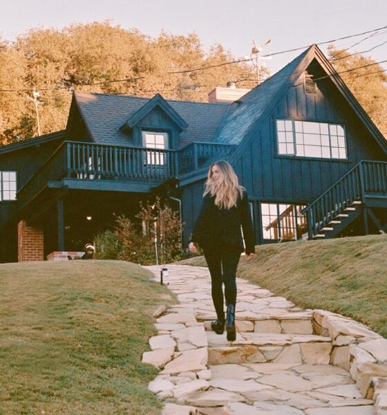 Woman standing out the front of a house in the fall