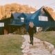 Woman standing out the front of a house in the fall