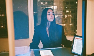 a female founder in tailored blazer mid action editing a multipage PDF contract on a large monitor