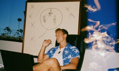 a focused male entrepreneur selling in his sleek office with a laptop open on the desk