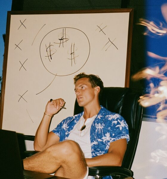 a focused male entrepreneur selling in his sleek office with a laptop open on the desk