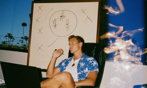 a focused male entrepreneur selling in his sleek office with a laptop open on the desk